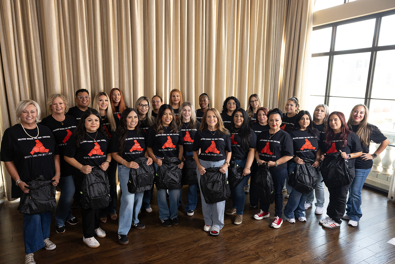 REEP and THRU Project team members gathered around donated backpacks